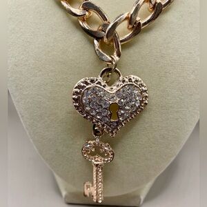 Diamond heart and key pendant on a rose gold tone chain link necklace. Romantic